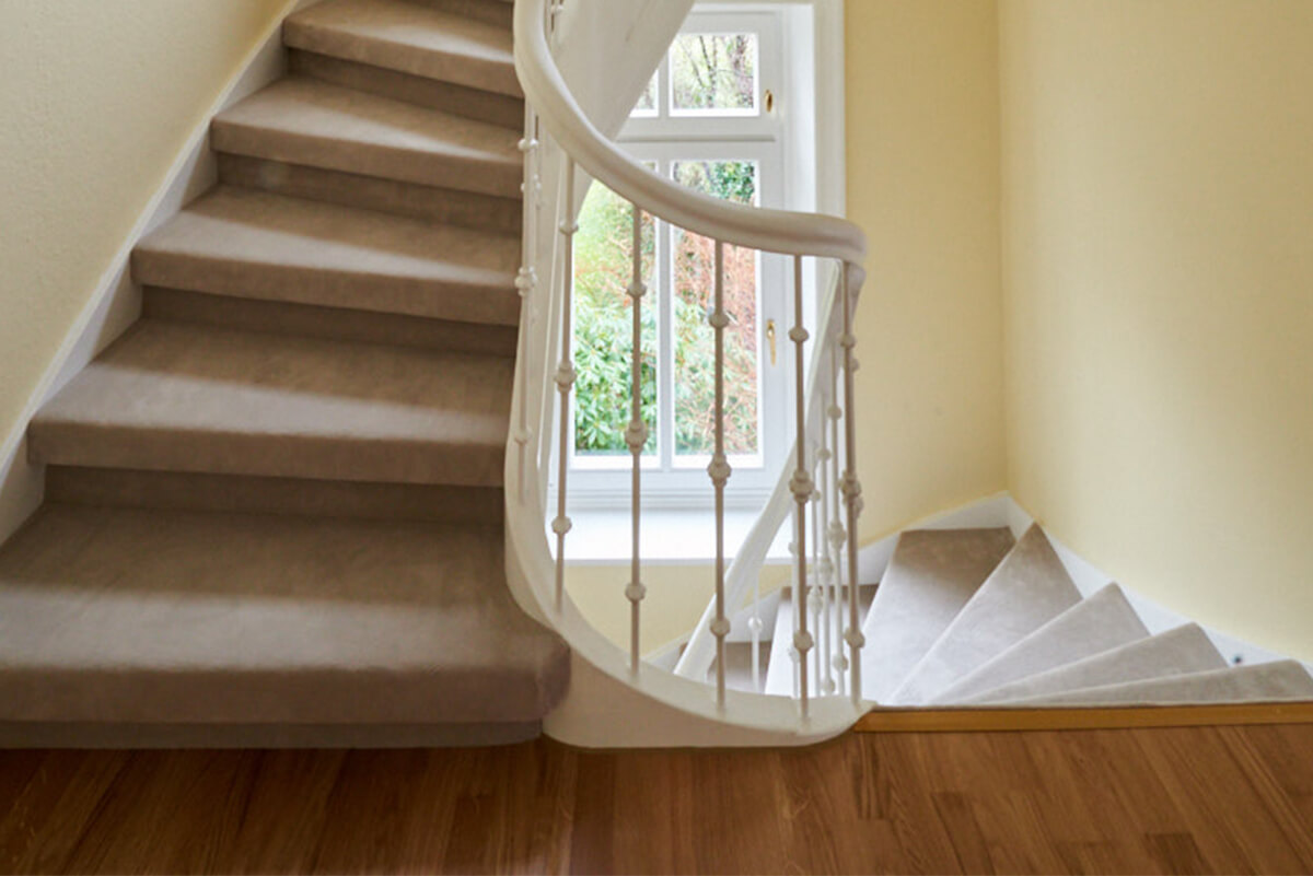 Renovierung einer Treppe mit Teppich auf den Stufen und Malarbeiten in einen Treppenhaus
